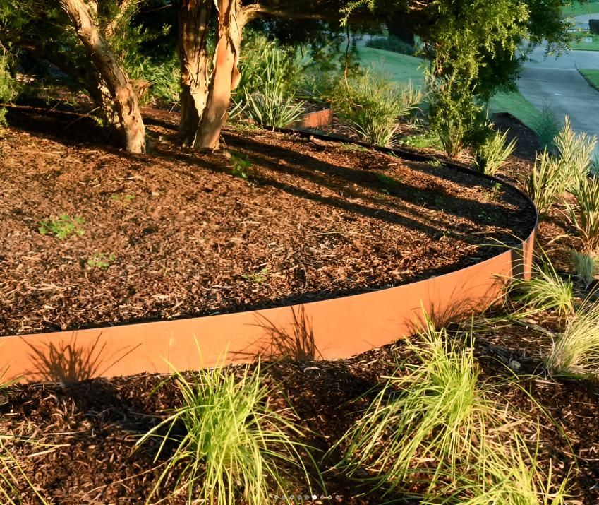 A Circular Garden With a Metal Border and Trees in the Background — Black Rock Garden Centre In Tyagarah, NSW