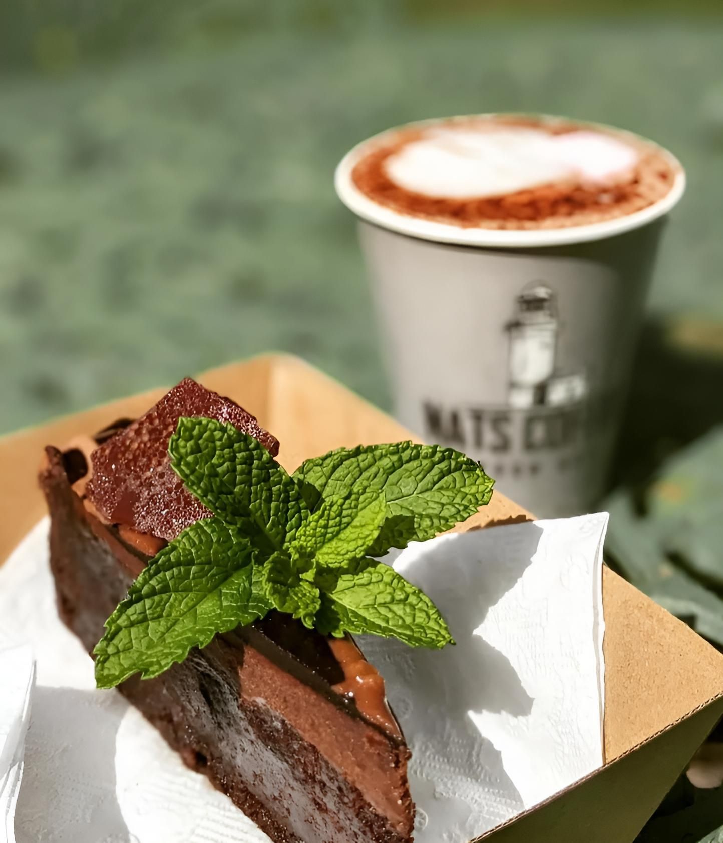 A Cup of Coffee and Slice of Cake With a Leaf on It — Black Rock Garden Centre In Tyagarah, NSW