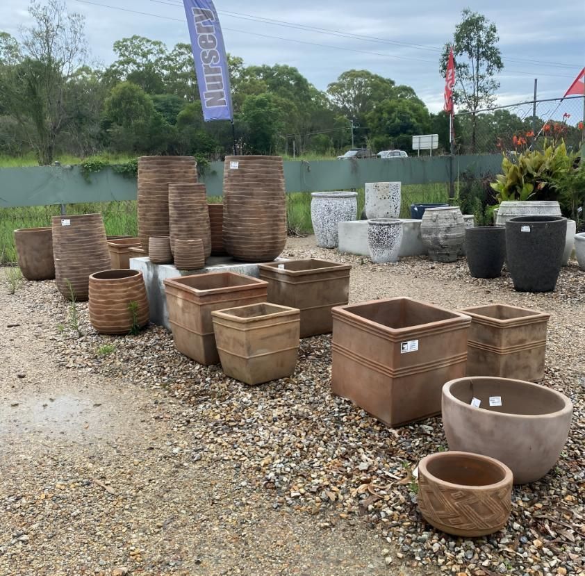 A Bunch of Pots Are Lined Up in a Gravel Area — Black Rock Garden Centre In Tyagarah, NSW