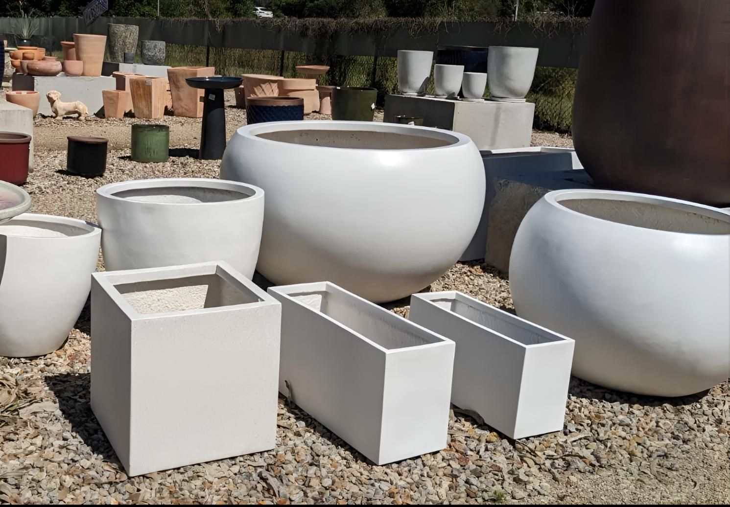 A Bunch of White Pots Are Sitting on Gravel — Black Rock Garden Centre In Tyagarah, NSW