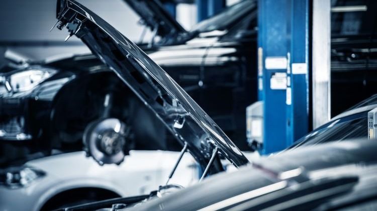 A car with its hood open in a garage.