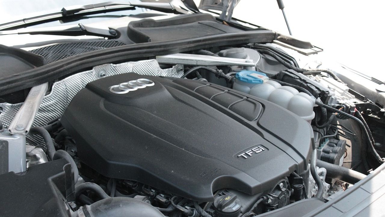 A close up of a car engine with the hood open.