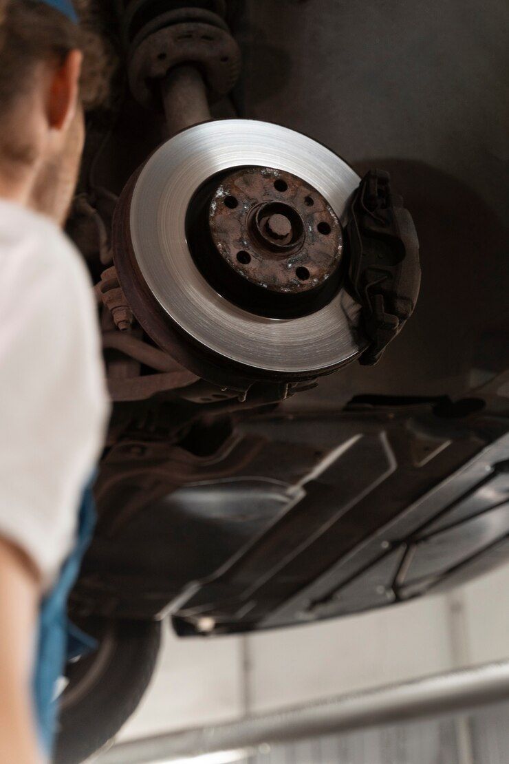 A person is working on the underside of a car.