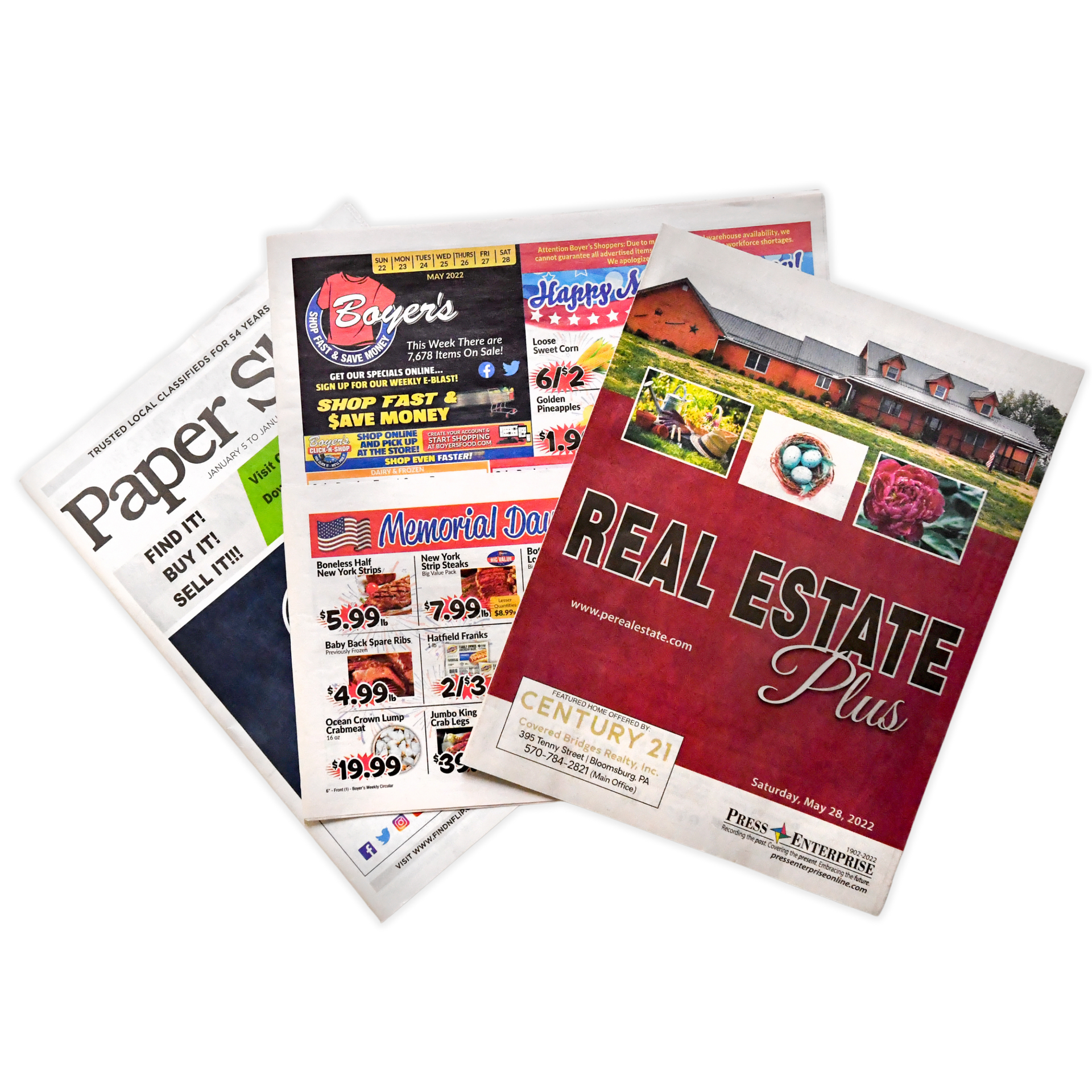 A stack of newspapers including one that says real estate plus by press enterprise commercial printing