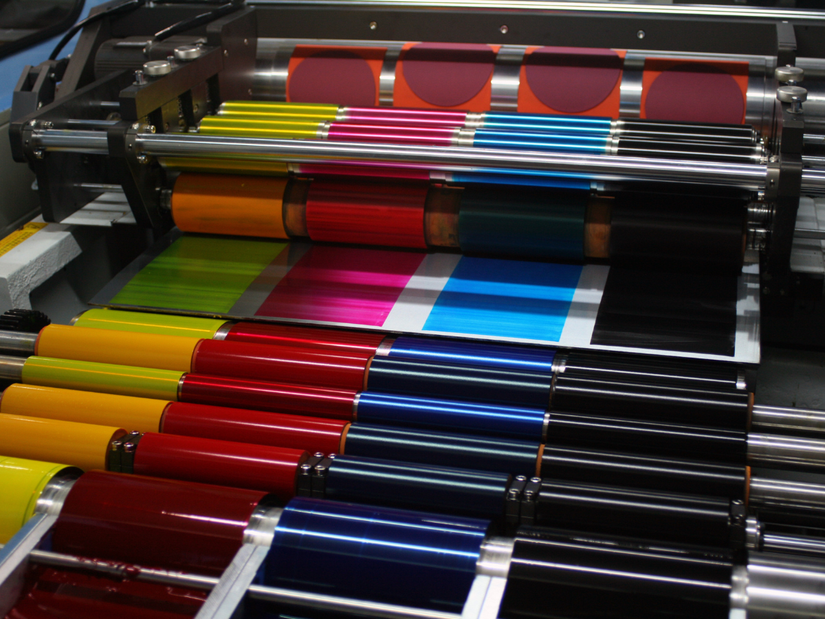 A bunch of different colored papers are being printed on a machine
