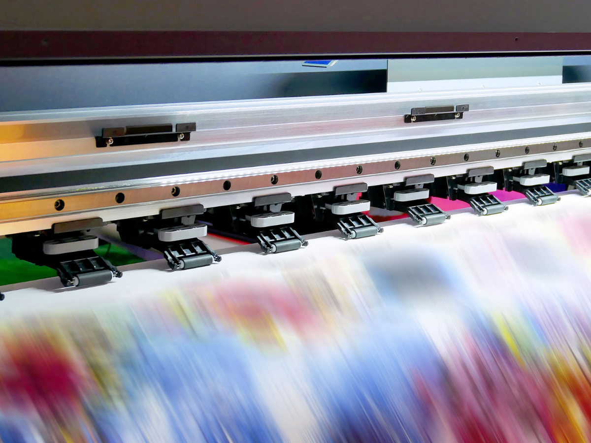A large printer is printing a large piece of paper.