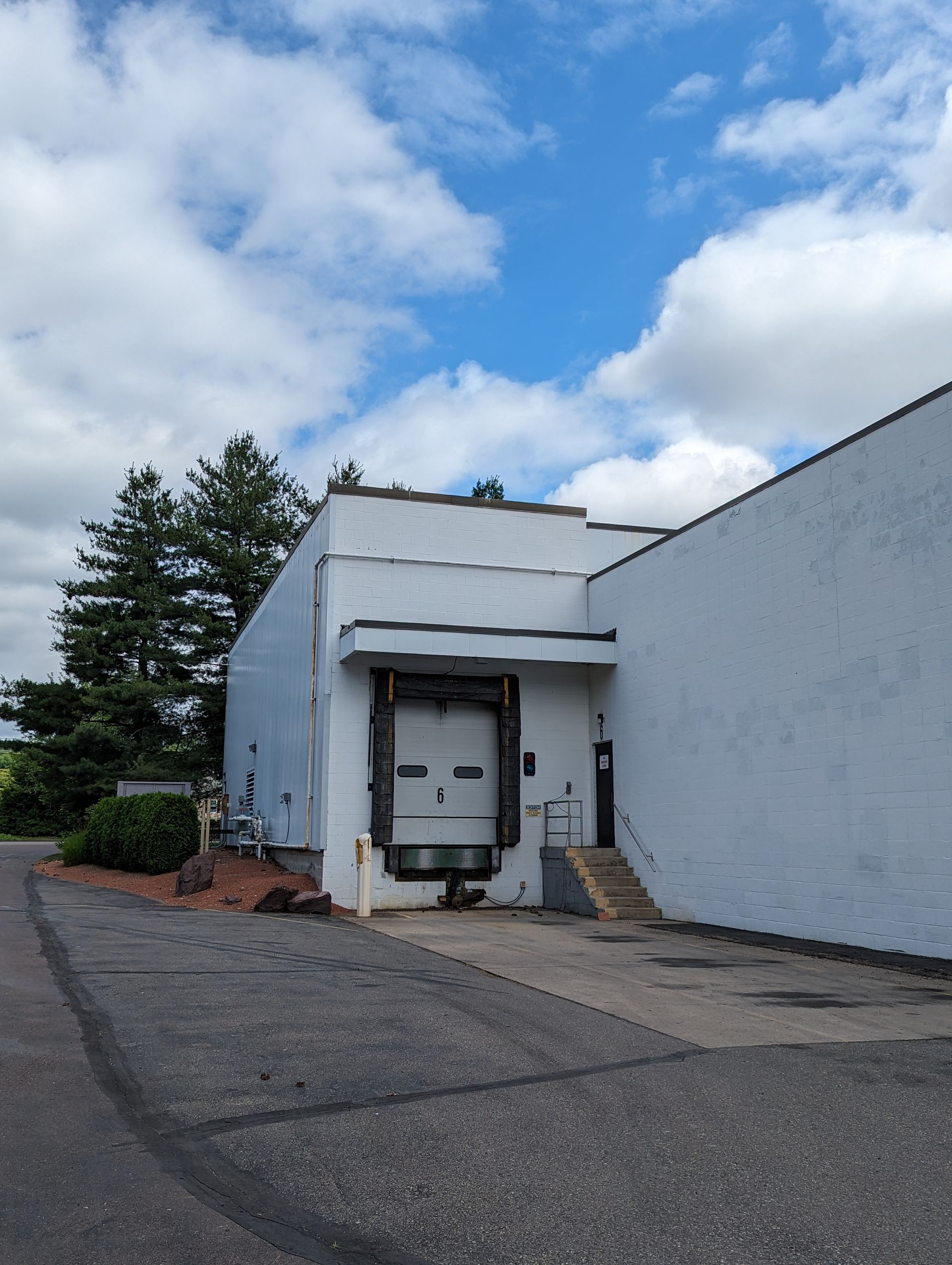 The back of a white building with a loading door