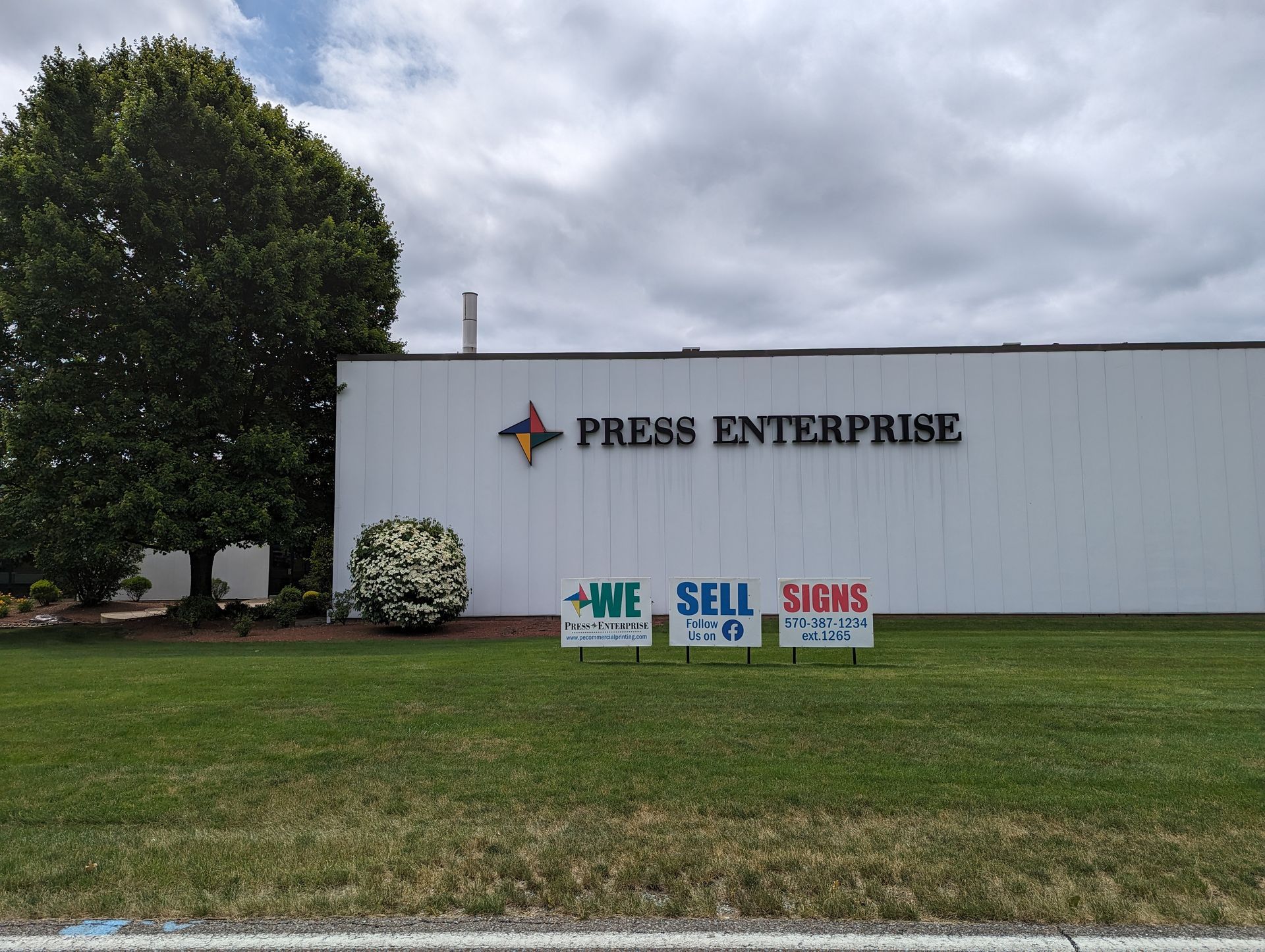 A white building with a sign that says press enterprise