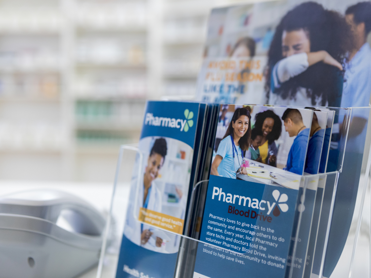 A display of pamphlets about pharmacy benefits in a pharmacy.