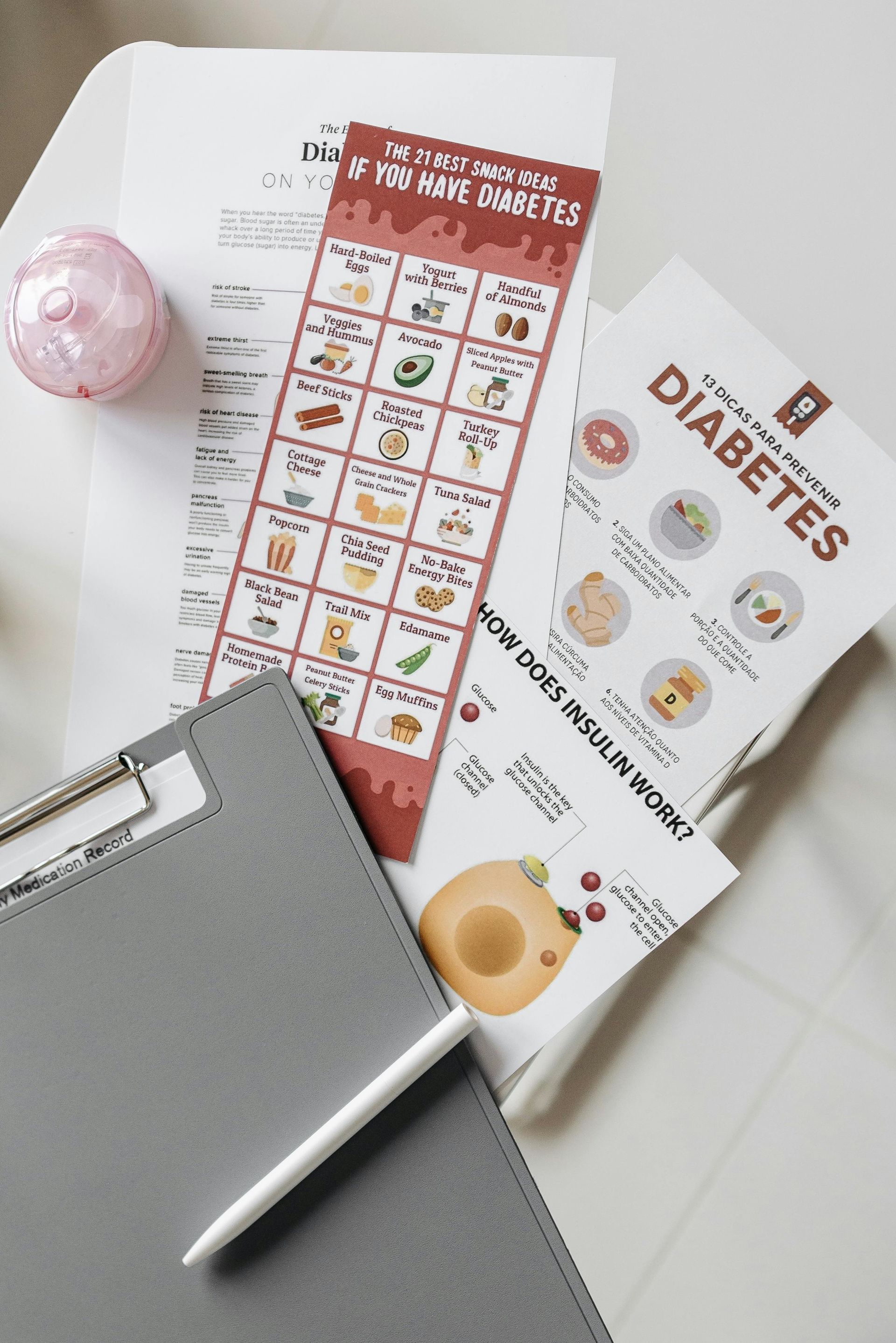 A clipboard with a pen and a book about diabetes on a table.