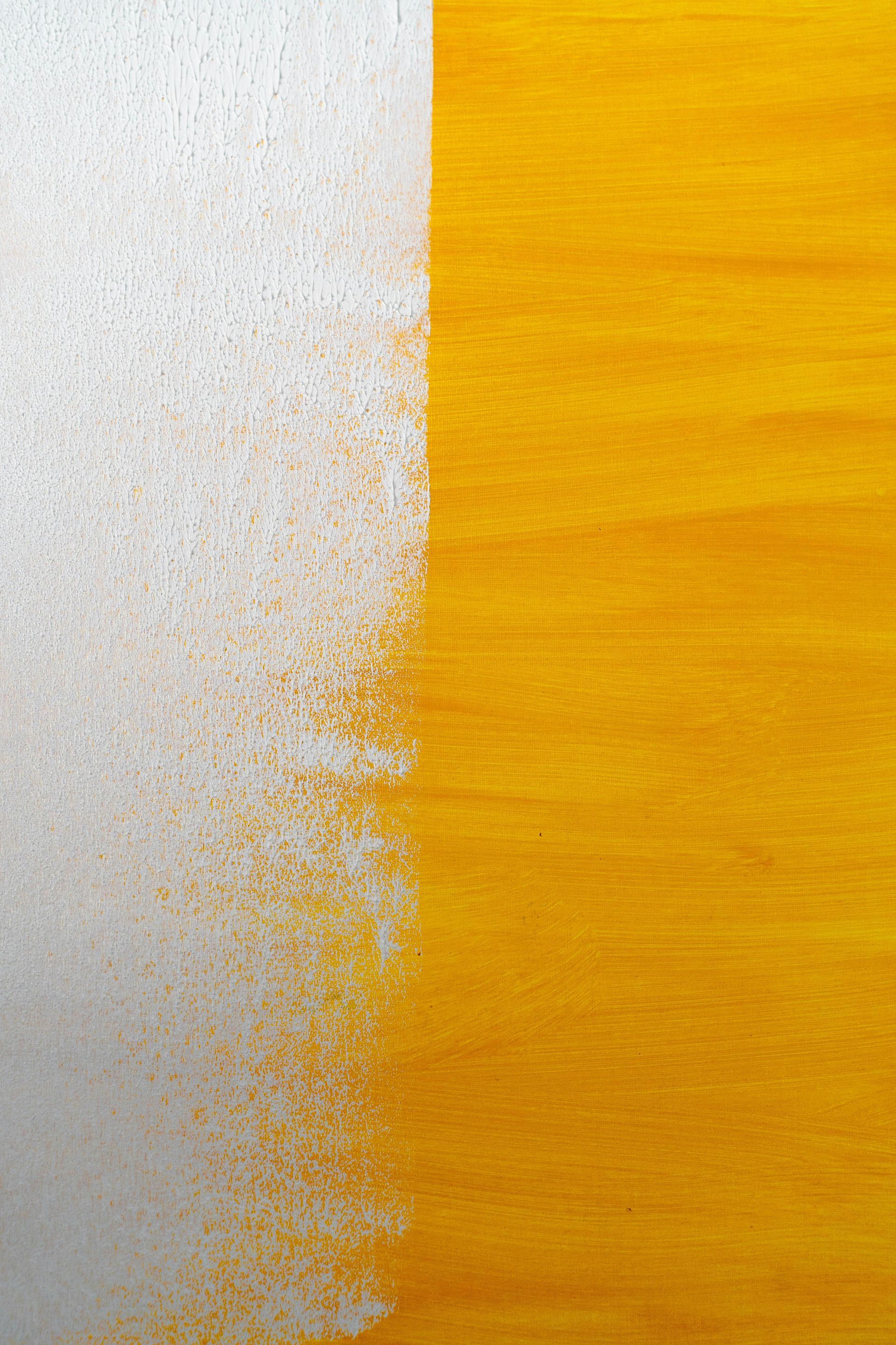 A close up of a yellow and white painting on a wooden surface.