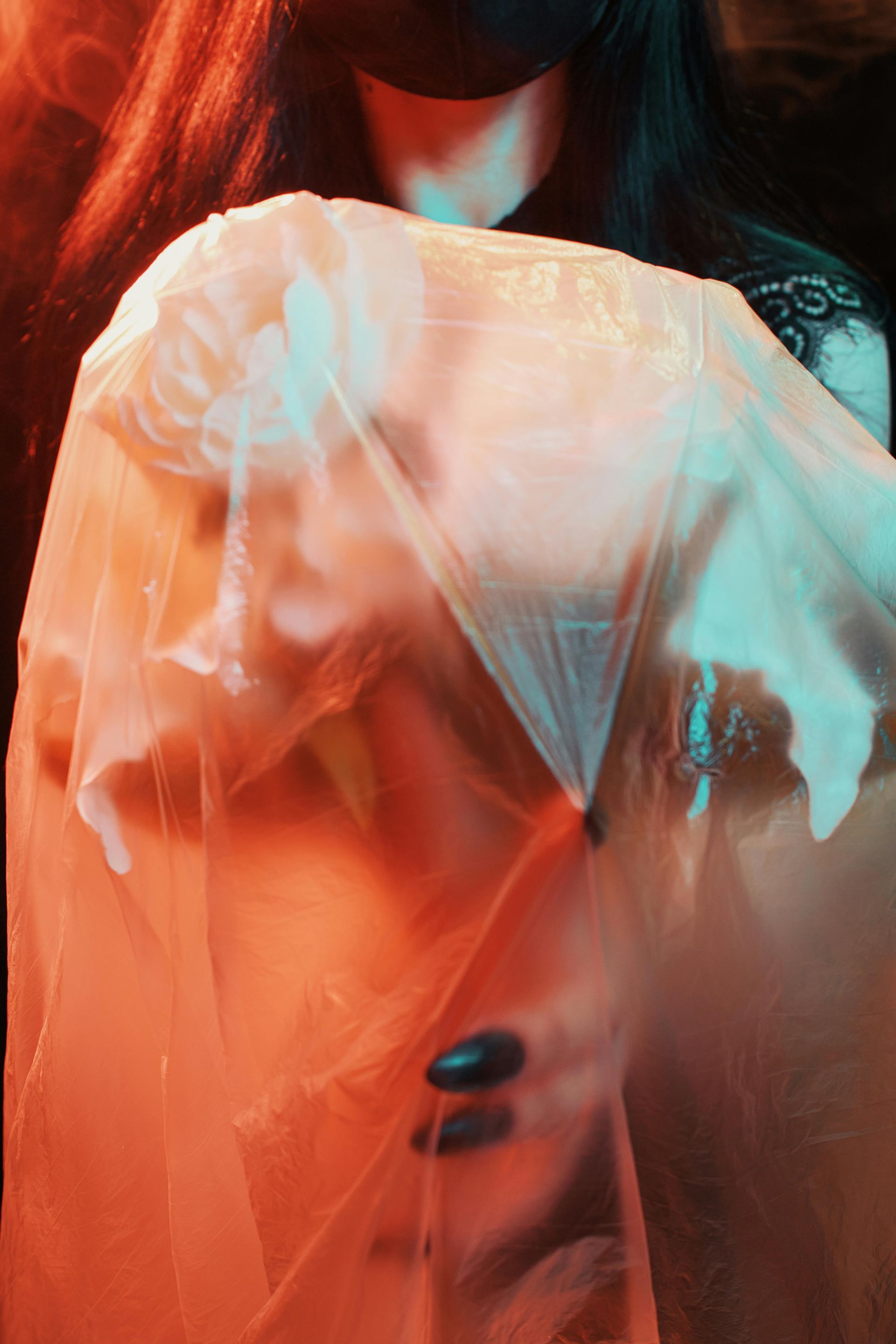 A woman is covering her face with a plastic bag.