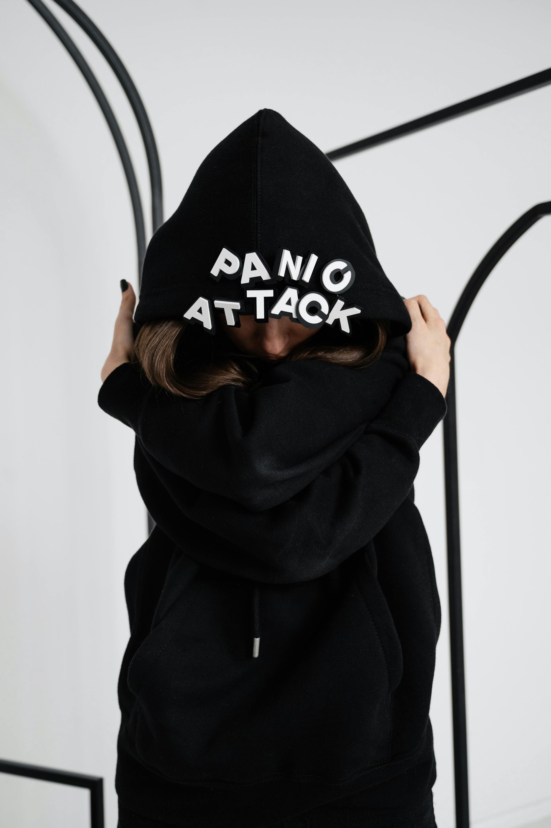 Person in black hoodie, pulling hood up; 