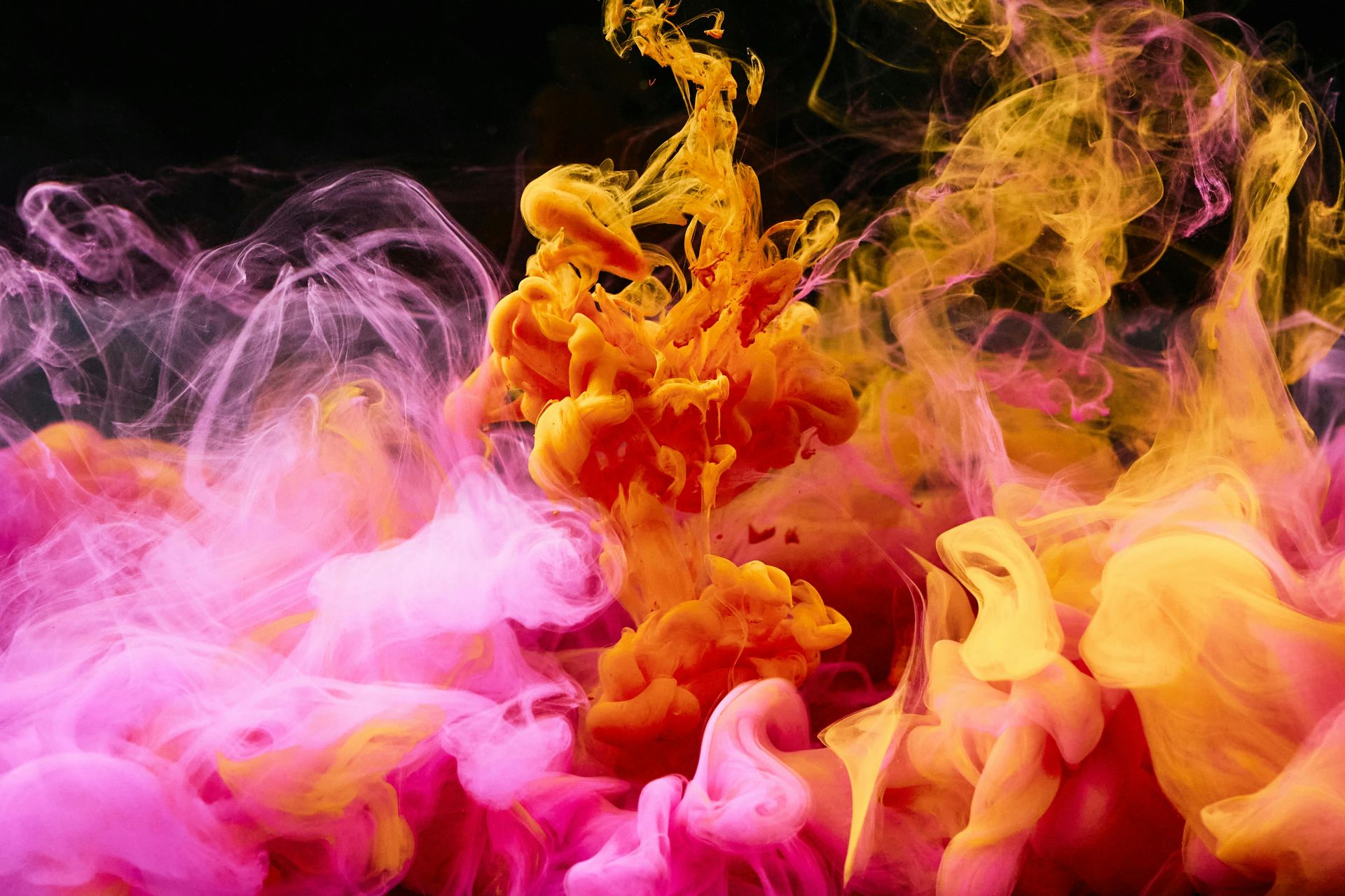 A close up of colorful smoke on a black background.