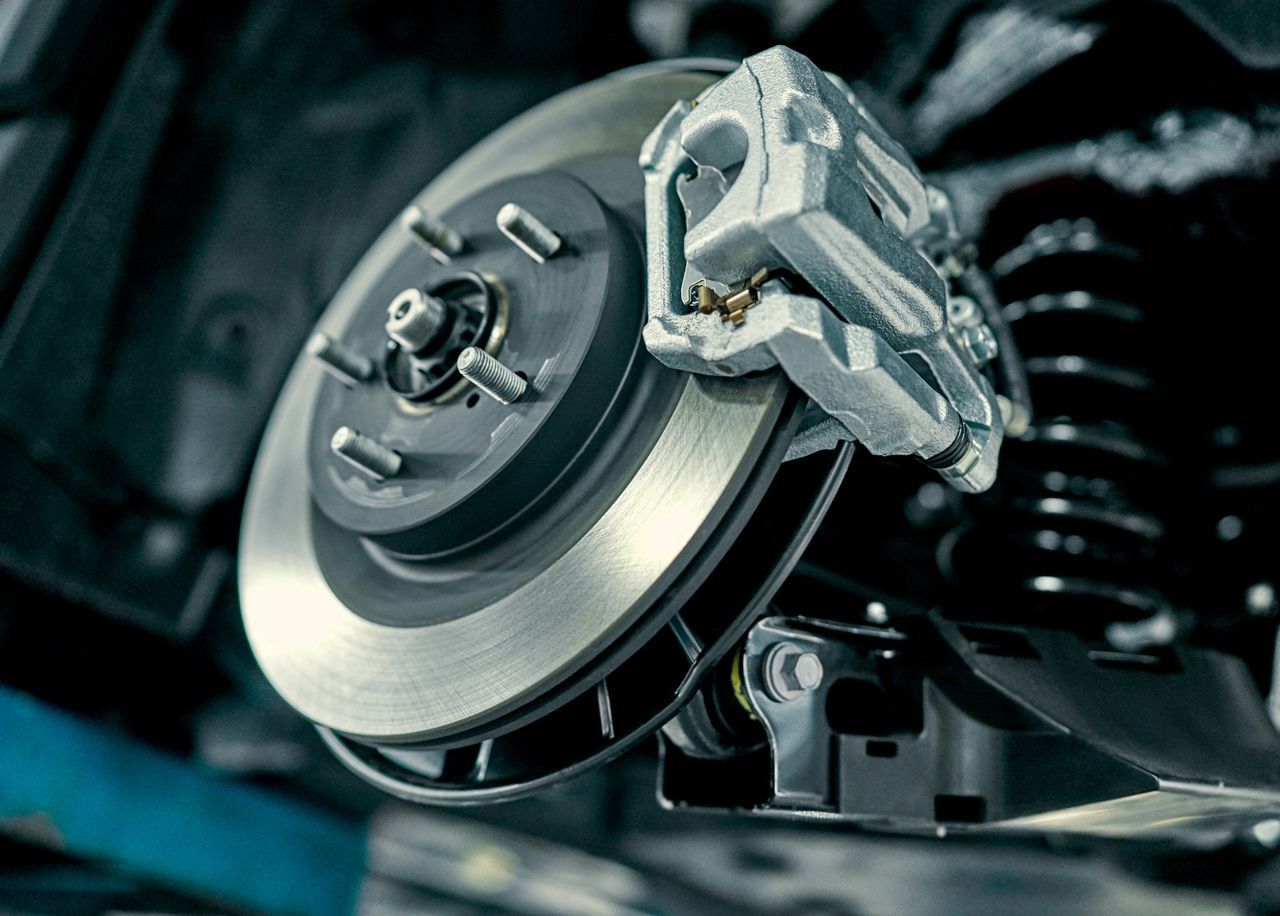 A close up of a brake disc and brake caliper on a car.