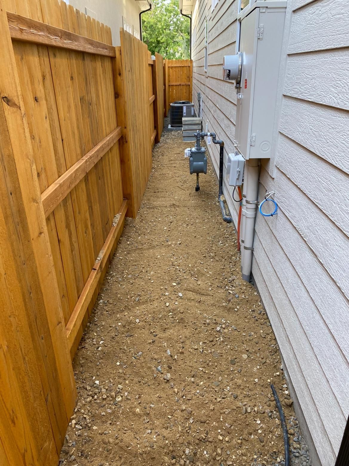 A wooden fence along the side of a house.
