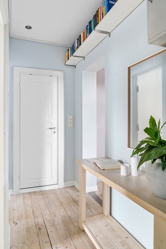 A hallway with a table and a plant on it
