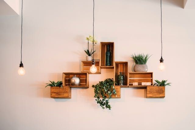 A wall with wooden shelves and potted plants on it.