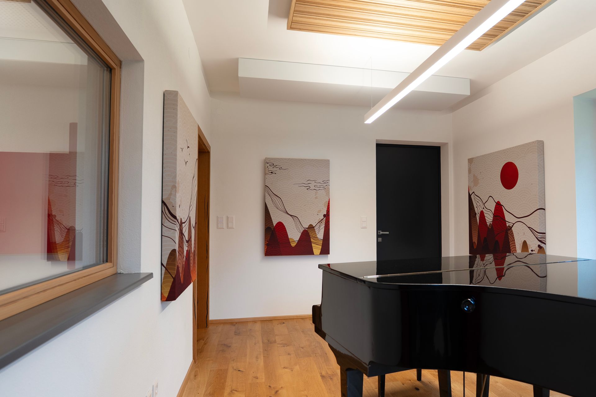 Flügel in einem Musikzimmer mit Gemälden, Holzboden und Fenster.