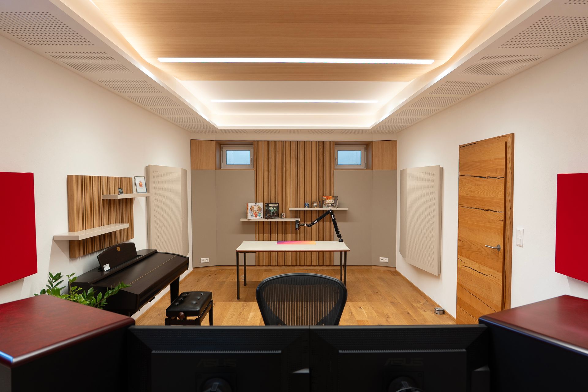 Tonstudio mit Holzelementen, Schallschutzpaneelen und Klavier.