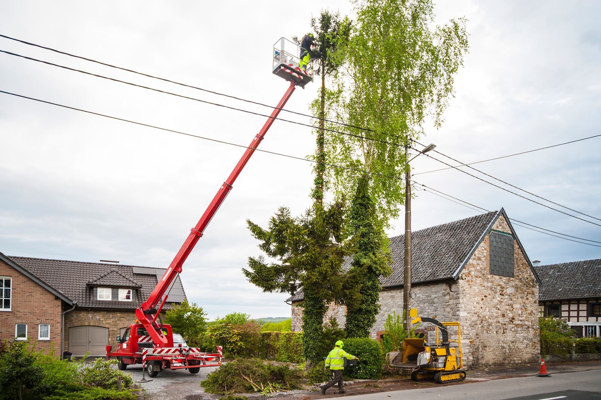Arborist Trimming Tall Tree Near Power Lines with A Boom Lift — Springfield, Oh — Huffman Tree Service