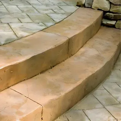 Two ceramic clay, low-carbon colored concrete steps lead to a stamped concrete patio in Naenae.