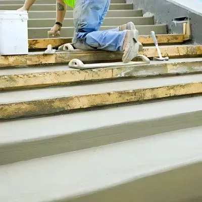 Concrete contractor troweling and finishing cement stairs on a commercial project in Stokes Valley.