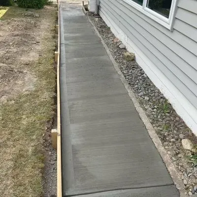 Front view of a cement walkway in Waterloo, showcasing a beautiful finish alongside our client's home.