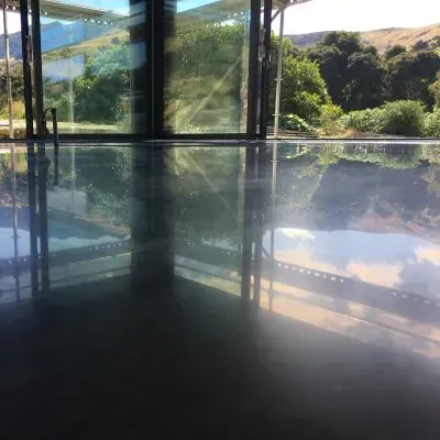 Mirror-gloss cream burnished polished concrete floor reflecting outdoor views in Naenae.