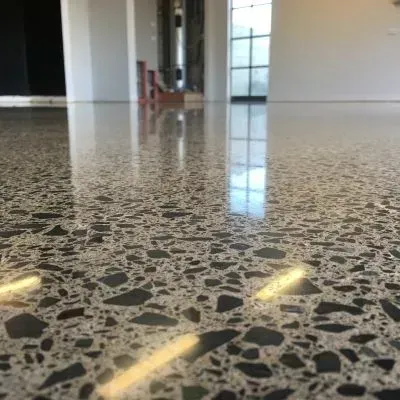 High‑gloss polished concrete with full aggregate exposure in a showroom, Boulcott, Lower Hutt.