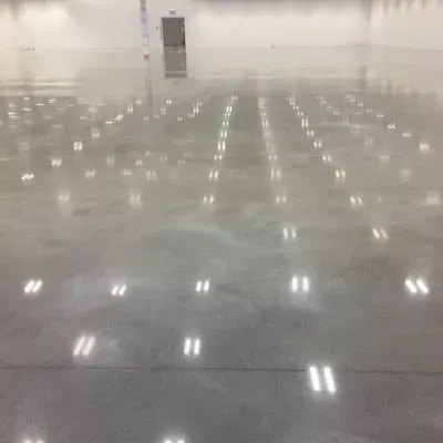 Industrial polished concrete warehouse floor with salt-and-pepper exposure and high-gloss finish in Seaview.