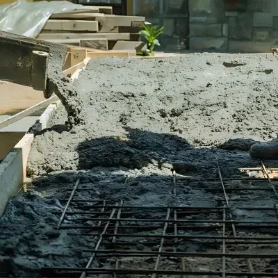 Close-up of 665 mesh reinforcement with concrete being poured over it in excavation for a driveway project in Kelson.