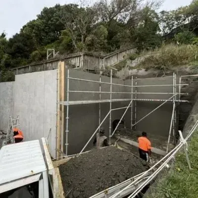 Completed sprayed concrete retaining wall (wide angle) with scaffolding in place, Karori, Wellington City.