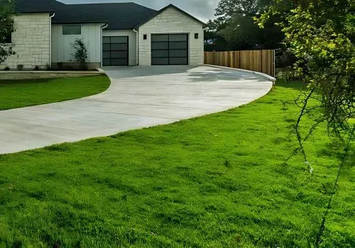 White curved concrete driveway leading to a house and garage in Eastbourne.