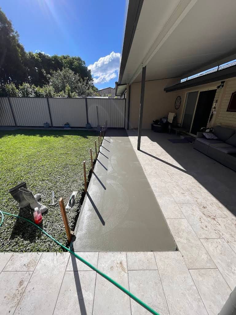 Fresh concrete walkway next to a grassy lawn and a patio — All Concrete Creations in Kingscliff, NSW