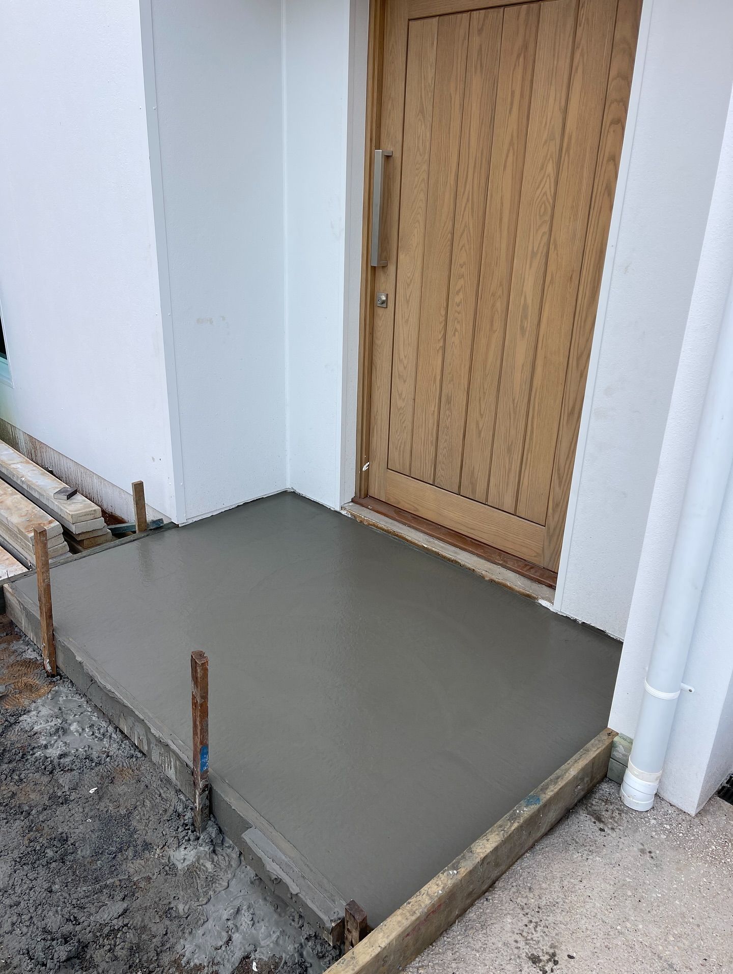 Freshly Poured Concrete Entryway in Front of a Wooden Door — All Concrete Creations in Robina, QLD