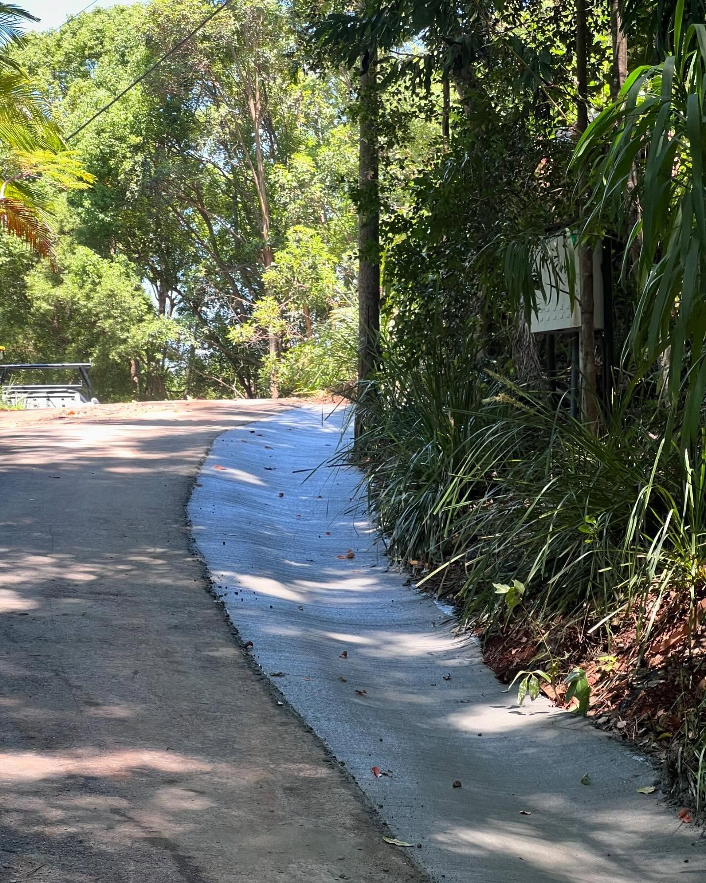 A Paved Walkway Alongside a Road, Bordered by Greenery — All Concrete Creations in Byron Bay, NSW