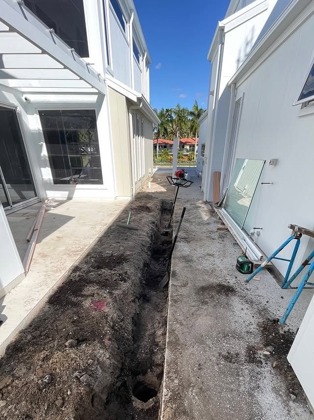 Trench Dug Between Two White Buildings With a Blue Sky Above — All Concrete Creations in Byron Bay, NSW