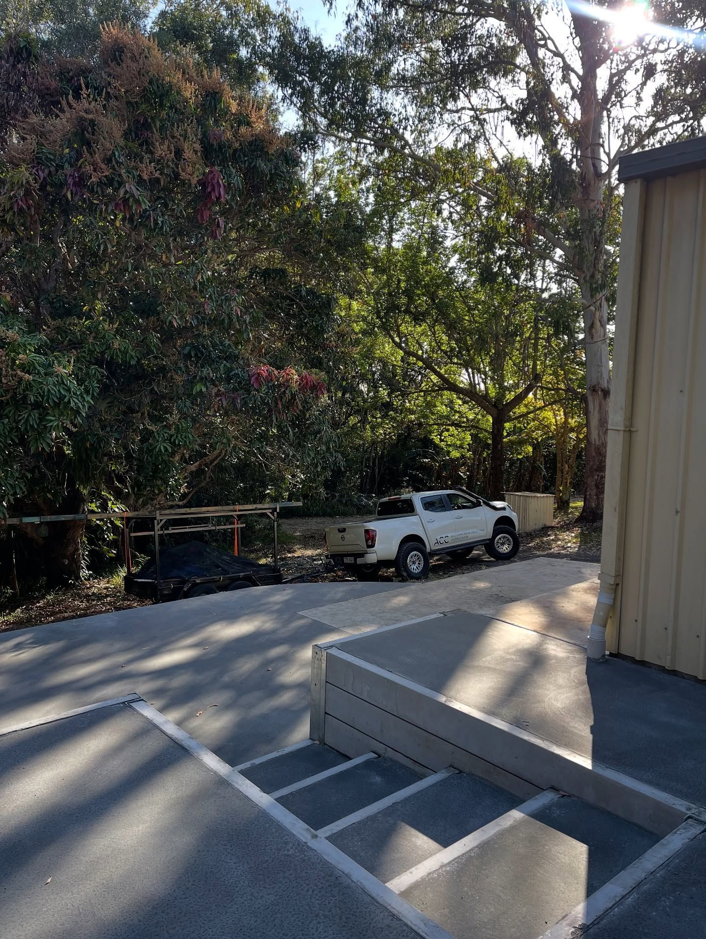 White pickup truck parked next to a building on a concrete surface — All Concrete Creations in Robina, QLD
