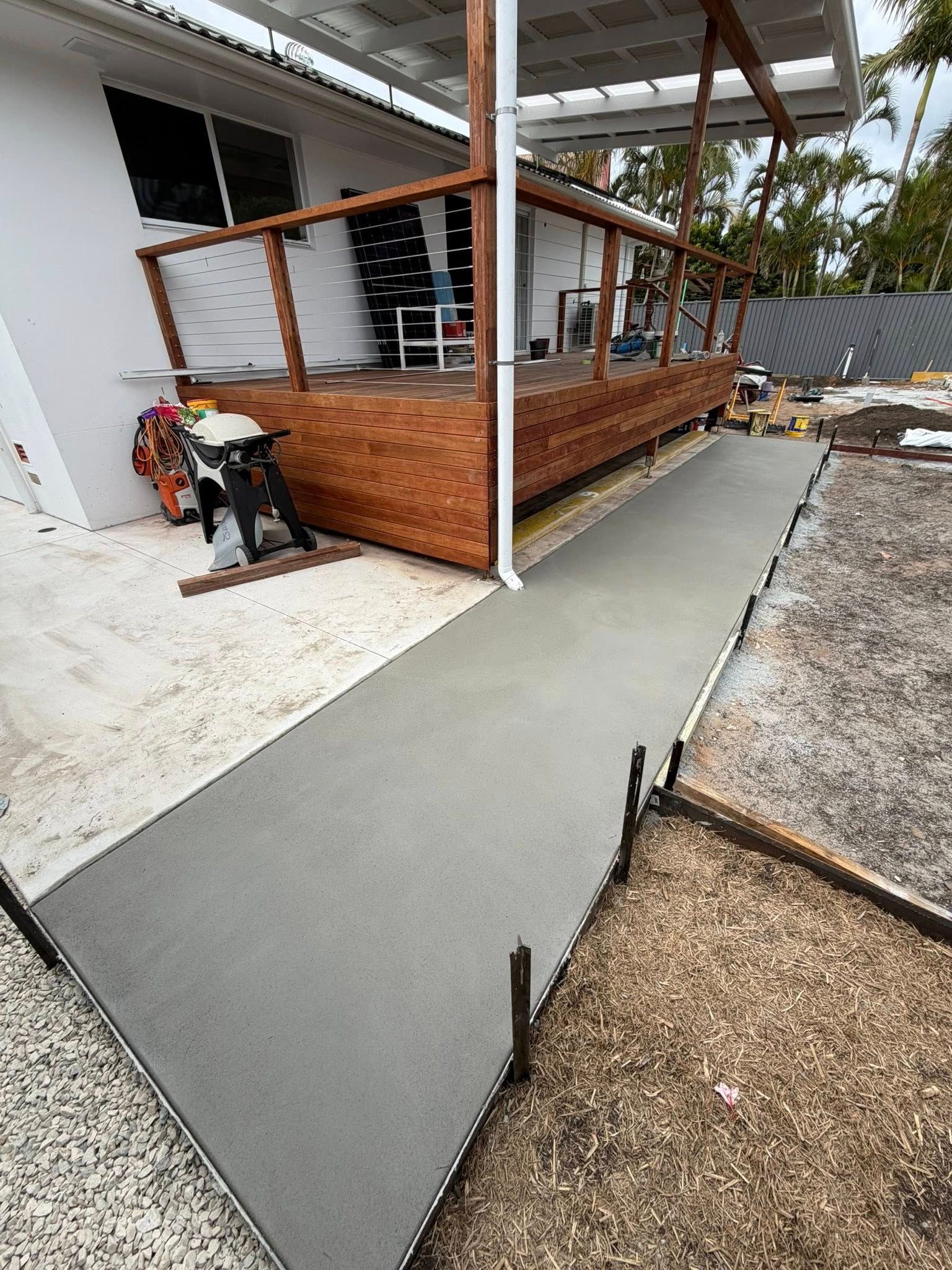 Newly Poured Concrete Walkway Next to a Wooden Deck, Outdoor Setting — All Concrete Creations in Kingscliff, NSW