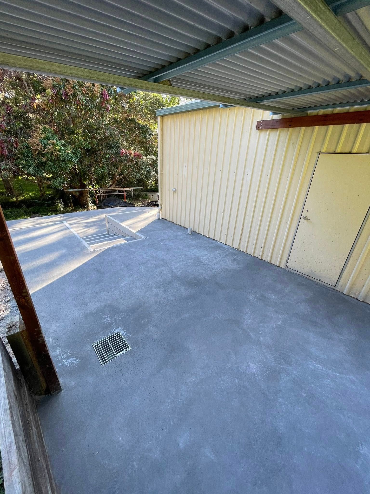 A Shaded Concrete Patio With a Shed and Trees in the Background — All Concrete Creations in Kingscliff, NSW
