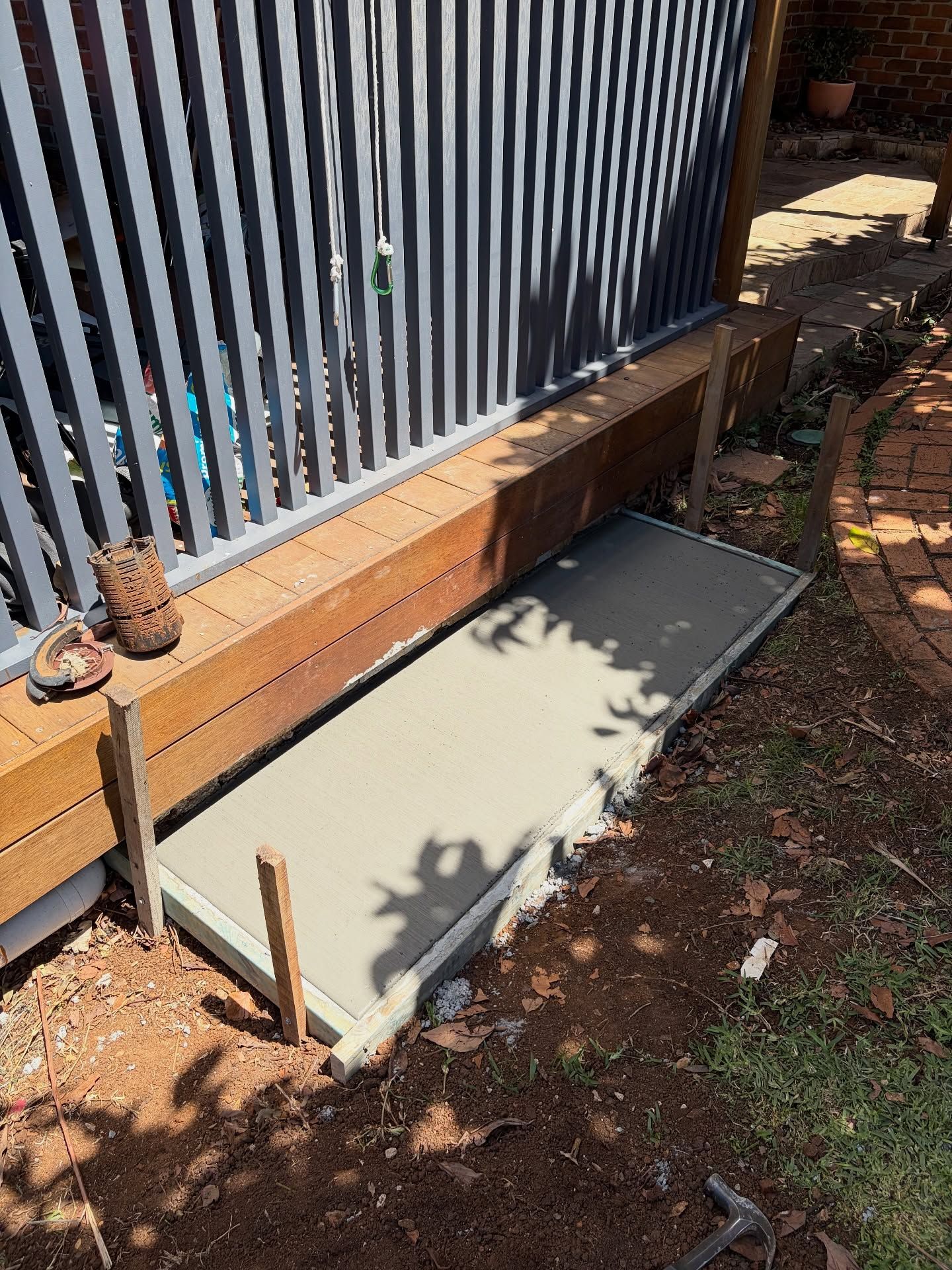 A Concrete Slab Installed Beside a Building With a Metal Fence — All Concrete Creations in Kingscliff, NSW