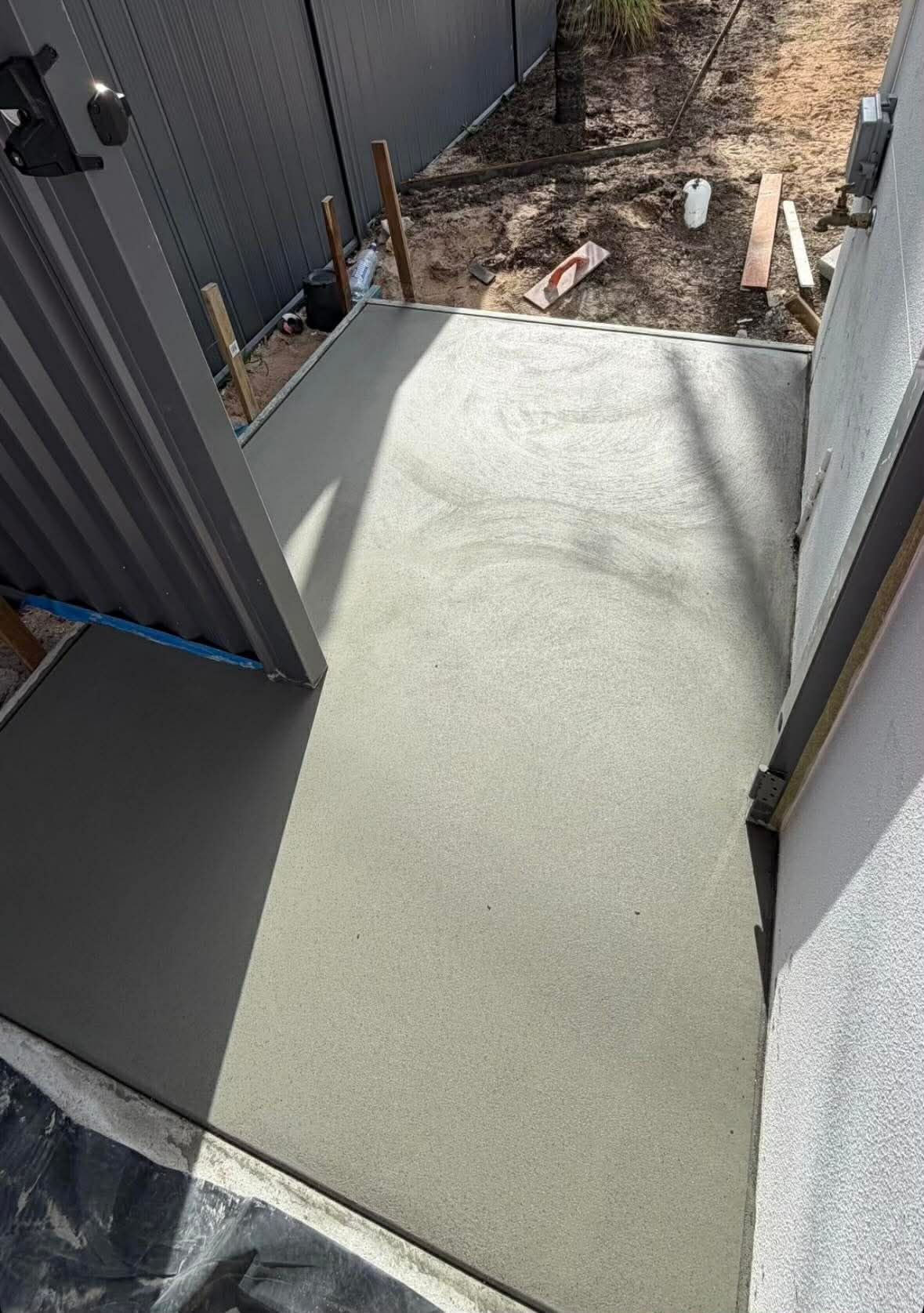 Newly Poured Concrete Pathway Between Two Walls, Leading to an Open Backyard — All Concrete Creations in Byron Bay, NSW