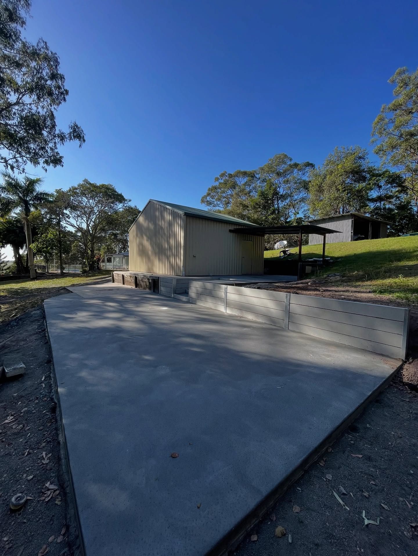 Concrete patio in front of a tan building with a sloped roof — All Concrete Creations in Kingscliff, NSW
