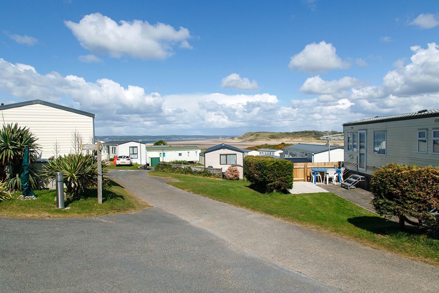 A row of mobile homes are parked on the side of a road.