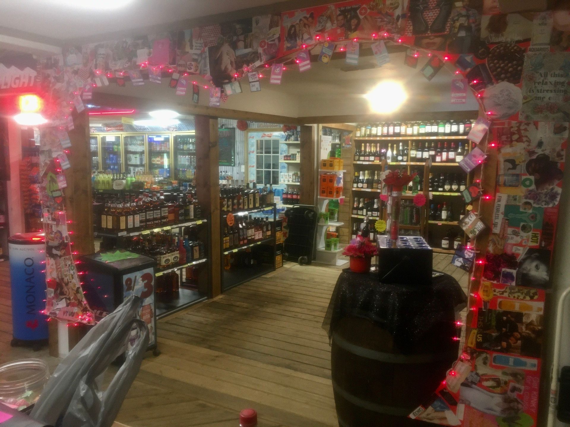 Liquor store interior with archway entrance decorated with lights, bottles on shelves.