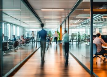 A group of people are walking down a hallway in an office building.