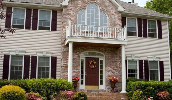 A Large Brick House With A Balcony And A Wreath On The Front Door | Omaha, NE | DRD Home Services