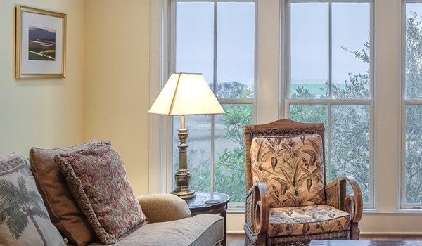 A Living Room With A Couch, Chair, Lamp And Two Windows | Omaha, NE | DRD Home Services