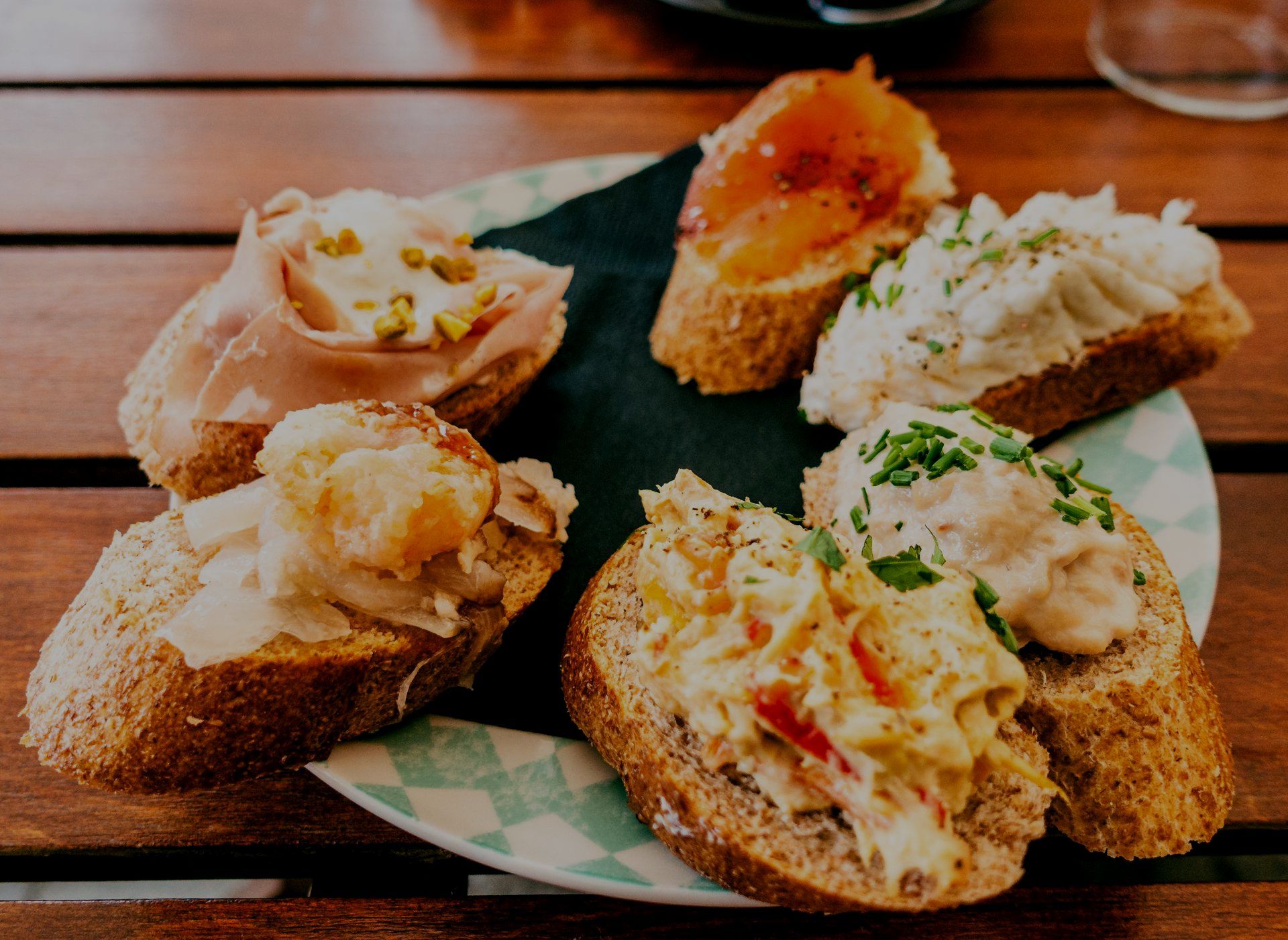 Un piatto di panini con diversi condimenti su un tavolo di legno.